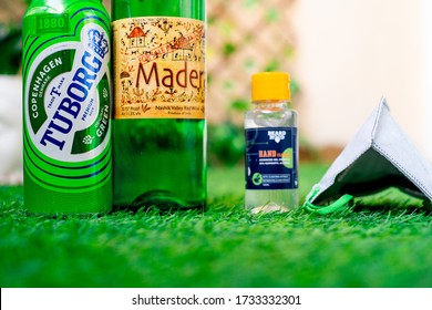 Gurgaon, Haryana, India - Circa 2020 : Alcohol Liquor Wine Beer Placed On Grass At The Entrance Of House With Mask And Sanitizer Showing Home Delivery Of Alcohol During Coronavirus Pandemic. Shows The