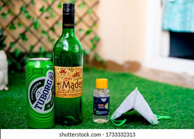 Gurgaon, Haryana, India - Circa 2020 : Alcohol Liquor Wine Beer Placed On Grass At The Entrance Of House With Mask And Sanitizer Showing Home Delivery Of Alcohol During Coronavirus Pandemic. Shows The