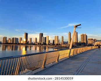 Gurney Bridge, an important link between Gurney Drive, and the small town in the Andaman Islands. City skyline reflects in calm waters below. Modern buildings stretch behind gentle clouds. Walking path invites quiet strolls beside metal railings.