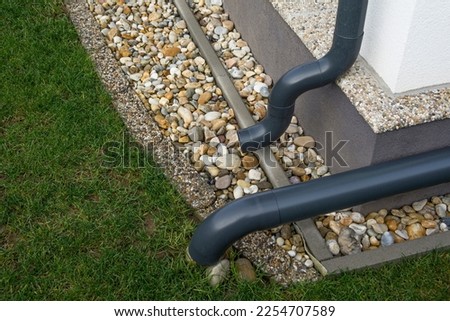Gutter elbow leads rainwater into the garden. Drainage system.