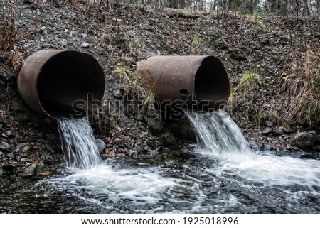 Gutter. Water runoff from a road spillway (water disposal, storm drain), two pipes and slow-flowing water (direct runoff)
