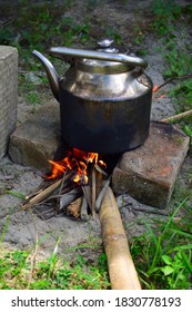 Guwahati, Assam, India-October 10 2020:Wood Fire Burning Below A Tea Kettle. Tea Kettle Is A Type Of Pot, Specialized For Boiling Water, With A Lid, Spout, And Handle, Or A Small Kitchen