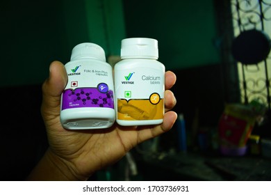 Guwahati,Assam,India - March 28 2020: A Person Holding Two Bottles Of Vestige Brand Calcium And Iron Tables And Capsules. These Are Used As A Supplements