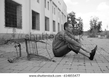 Foto Bild junger Mann, der in der Nähe des Korbes sitzt.