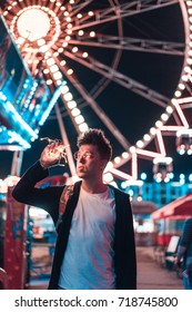 Guy in an amusement park posing at the camera