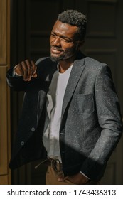 Guy In A Beautiful Jacket By The Window. African American Groom At Home In A Cozy Interior. Stylish Young Man Middle Portrait By The Window. Handsome Young Man Model - Average Plan