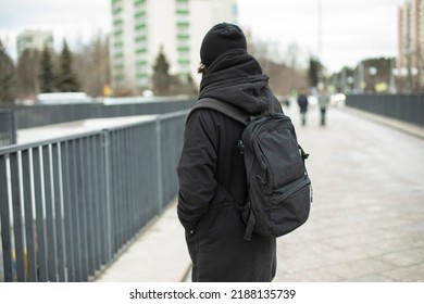 Guy In Black Clothes On Street. Man's Black Backpack. European In City. Style Of Dress Is All Black.