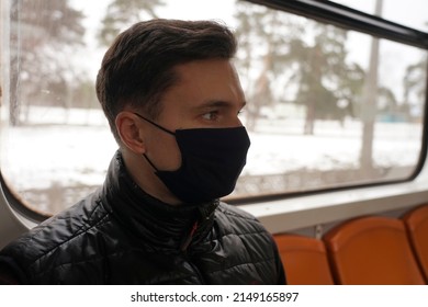 A Guy In A Black Mask Sits In A Subway Car Near The Window