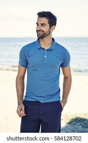 Guy In Blue Polo Shirt On Beach, Smiling