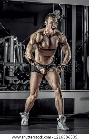 guy bodybuilder, perform exercise with exercise machine crossover, in gym