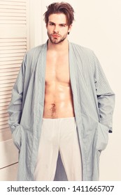 Guy Or Bodybuilder With Sexy Figure In Home Or Bath Clothes. Morning, Spa And Masculinity Concept. Man With Beard In Blue Dressing Gown On White Background. Macho In Bathrobe With Torso And Six Packs.