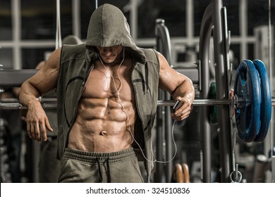 guy bodybuilder tired in gym and listen music with headset 