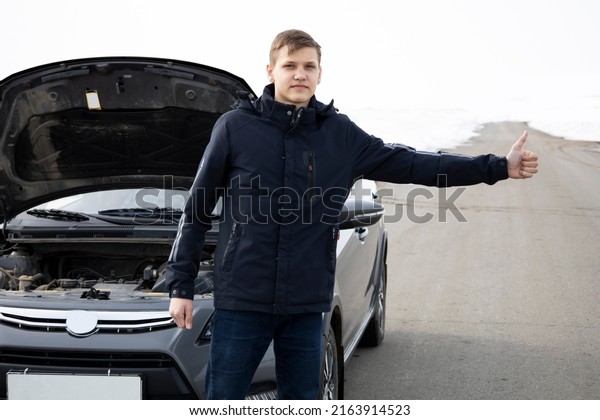 The guy broke down the car he asks for help from\
other drivers.