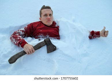 A Guy Buried In Snow Looks At The Camera, Holding An Axe In One Hand And A Thumbs-up In The Other.