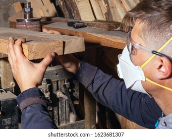 A Guy A Carpenter, A Craftsman In A Respirator And Construction Glasses, Selects Wooden Boards For And Processing The Blanks Of His Products. Woodworking Concept  .
