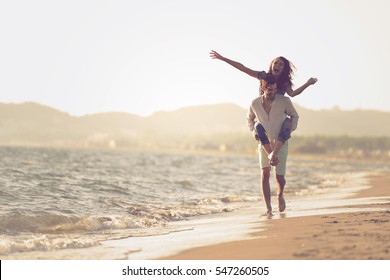 A guy carrying a girl on his back, at the beach, outdoors - Shutterstock ID 547260505
