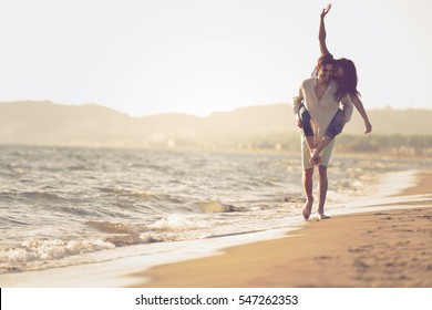 A Guy Carrying A Girl On His Back, At The Beach, Outdoors