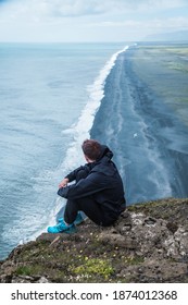 Guy in a cliff with the beach behind