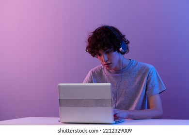 guy cyberspace playing with headphones in front of a laptop isolated background - Shutterstock ID 2212329009