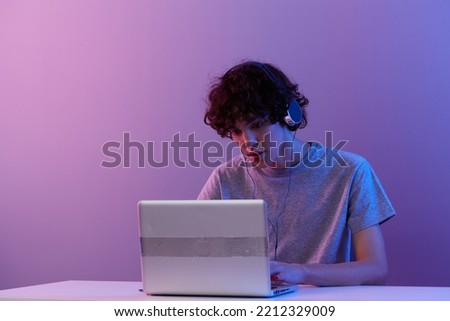 guy cyberspace playing with headphones in front of a laptop isolated background