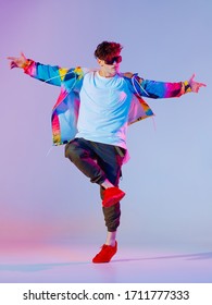 Guy Dancing Contemporary Dance In Studio. Neon Light Grey Background. Acrobatic Bboy Dancer. Break Dance Lessons.