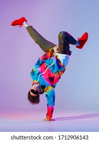 Guy Dancing Contemporary Dance In Studio. Neon Light Grey Background. Acrobatic Bboy Dancer. Break Dance Lessons.