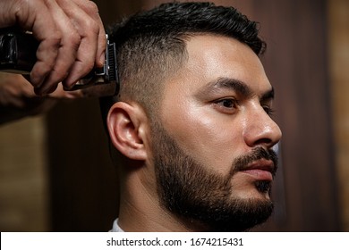 The Guy Is A Dark-haired Asian Indian Appearance On A Haircut In A Barbershop . Cinematic Image