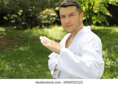 Guy doing a martial arts pose in the park  - Powered by Shutterstock