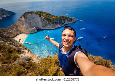 A guy doing selfie on a background of a shipwreck. Novagio beach. - Powered by Shutterstock