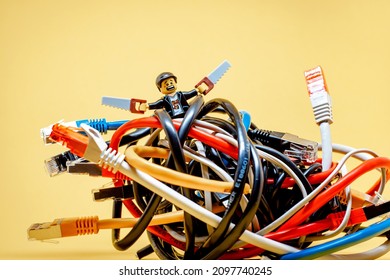 IT Guy Fighting A Bundle Of Tangled Wires. Information Technology Concept. Illustrative Editorial. December 25, 2021