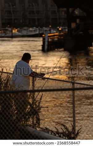 Guy fishing under bridge during sunset