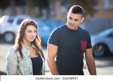 Guy Flirting With Young Woman On Sunny City Street With Car Parking In Summer, Looking At Her With Smile, Talking