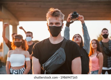 Guy at the front of crowd. Group of protesting young people that standing together. Activist for human rights or against government.