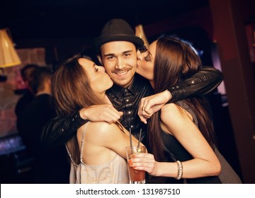 Guy gets a friendly kiss on the cheek by attractive party girls