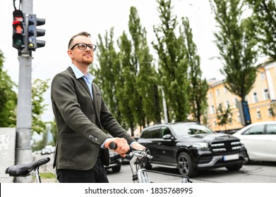 The guy gets to work on a bicycle. Young man in stylish smart casual clothes on a bicycle in city traffic