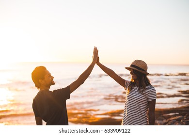 Guy And Girl High Five At Beach Sunset