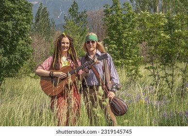 Guy and a girl in hippie style with a guitar in a forest clearing on a sunny day - Powered by Shutterstock - Get 15% off with code: PIKWIZARD15