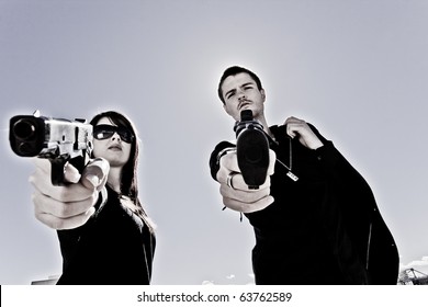 Guy and a girl pointing two guns