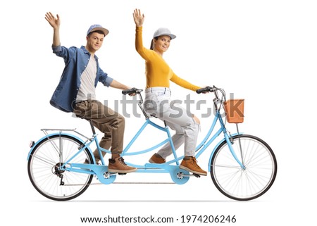 Guy and girl riding a tandem bicycle and waving at camera isolated on white background
