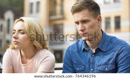 Guy and girl sitting next to each other, gloomy faces, first fight, relationship