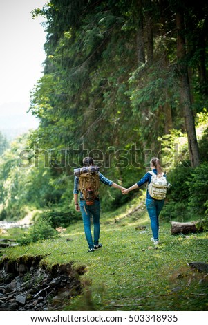 A guy and a girl tourists they go camping in the mountains