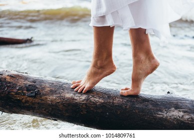 A Guy And A Girl Walk On The Beach Barefoot, The Girl Rolls The Waves And Pours It With Water Splashes, The Girl Walks On A Log Lying On The Beach Neatly Stepping Barefoot