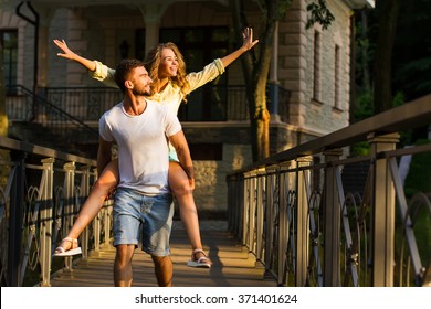 Guy and girl walking along the beautiful ranch. A romantic walk in the night park. Couple in love on the bridge.