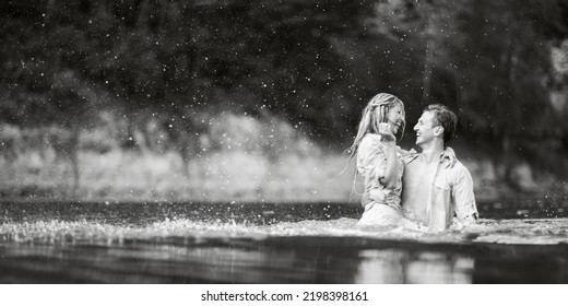 The Guy And The Girl Are Wet Kissing While Standing In The Water. Wet Clothes. Black And White Photography. Water Splashes Around.