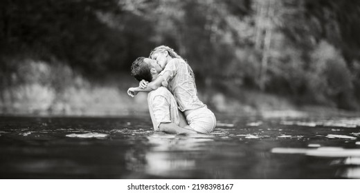 The Guy And The Girl Are Wet Kissing While Standing In The Water. Wet Clothes. Black And White Photography.