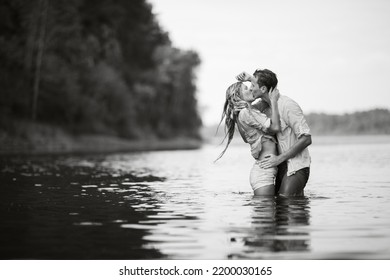 The Guy And The Girl Are Wet Kissing While Standing In The Water. Wet Clothes. Black And White Photography.