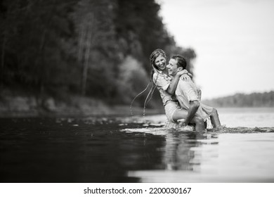 The Guy And The Girl Are Wet Kissing While Standing In The Water. Wet Clothes. Black And White Photography.