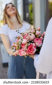 The Guy Gives The Girl Flowers On The Street, Vertical Photo 