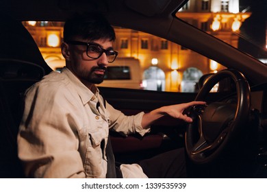 Guy With Glasses Driving A Car At Night