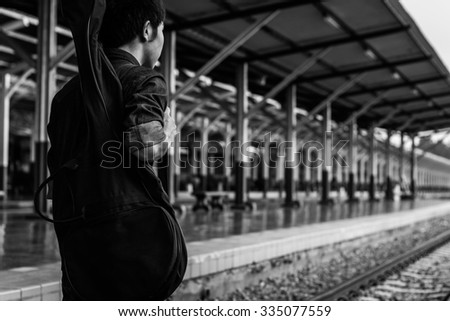 Guy with guitar on the railway road. Black and white photo
